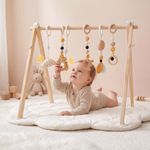 Baby reaching for toys on Montessori wooden play gym