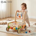 Toddler pushing Baby Einstein x labebe wooden push walker while learning to walk