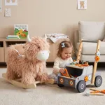 Toddler playing with tool bench walker with Yak plush rocker placed nearby