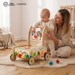 Parent helping toddler take first steps using Baby Einstein wooden activity walker