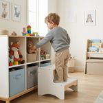 Toddler using wooden 2-step stool for play and daily routines, child-friendly design