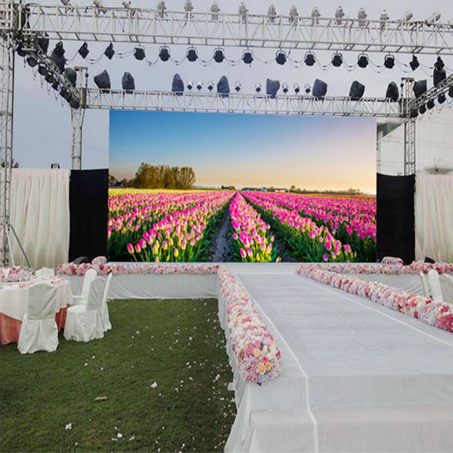 A portable LED display screen with a lush tulip field image