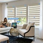 Voice activated smart zebra shades in a contemporary living room, controlled via smart speaker with "Open the shades" command for natural lighting